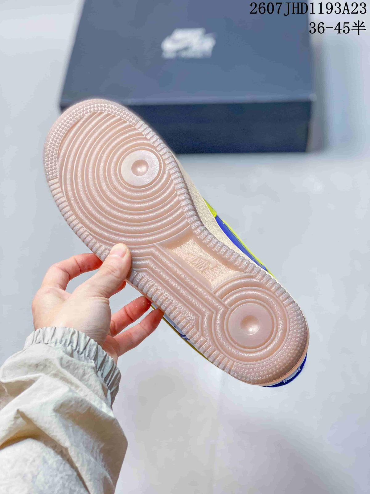 Underside view of a sneaker showing the light-colored circular-groove rubber outsole.