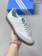 Angled side view of the white sneaker showing SAMBA lettering, three stripes, and gray toe detailing.