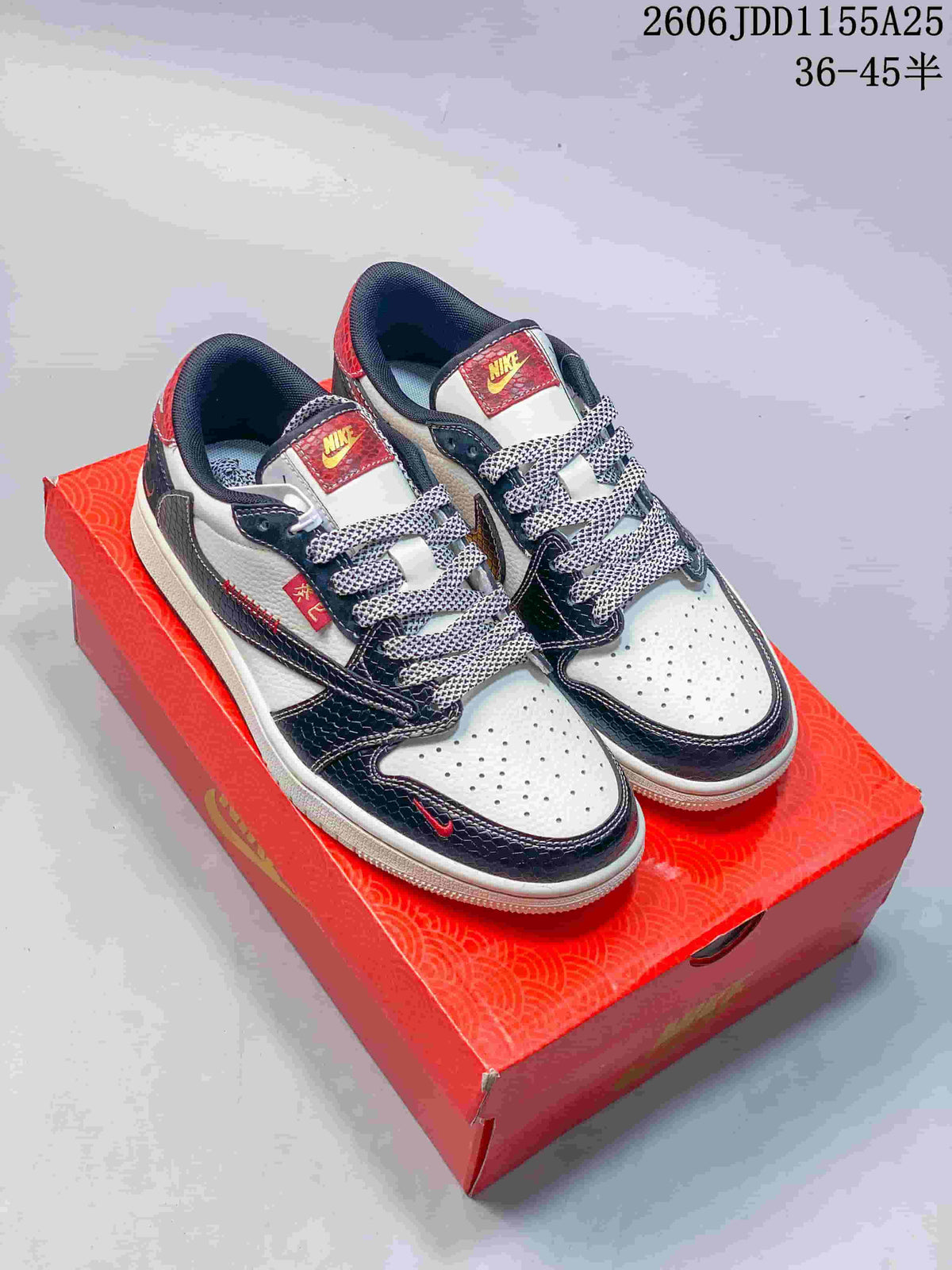 Pair of white low-top sneakers with dark overlays, red accents, and patterned laces