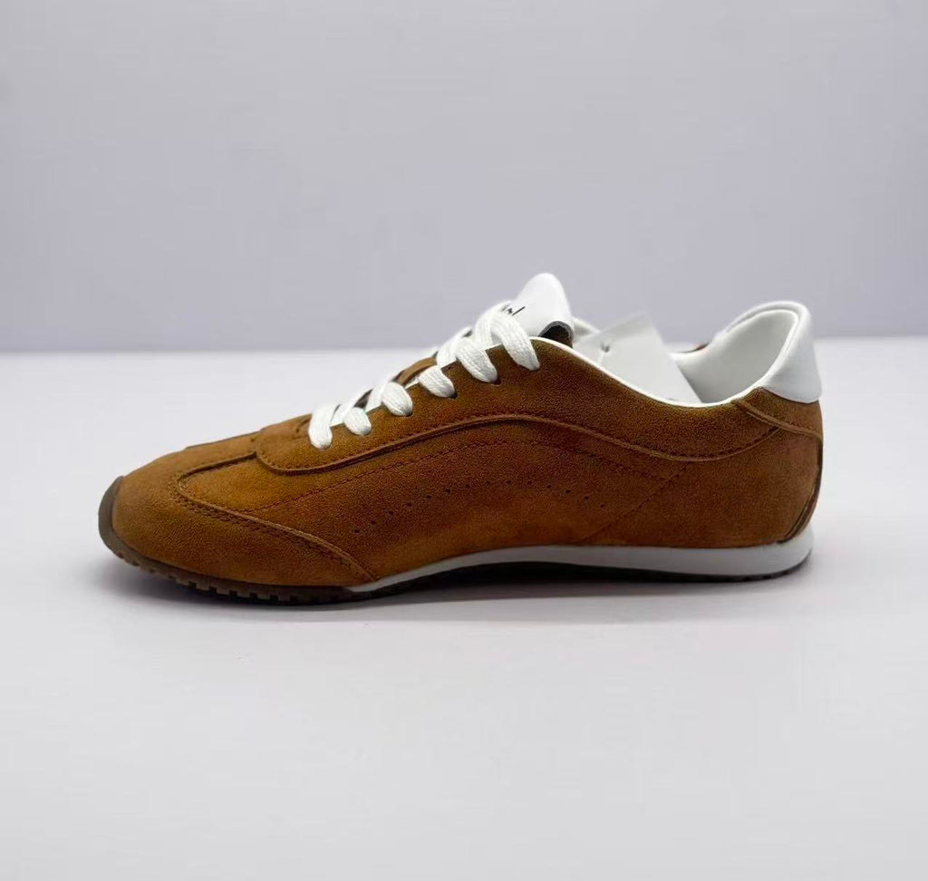 Opposite side view of the brown low-top sneaker with white laces and layered stitched panels.