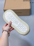 Outsole view showing the off-white textured tread and monogram-style detailing.