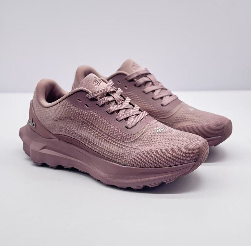 Pair of pink alo sneakers shown from a front three-quarter angle.