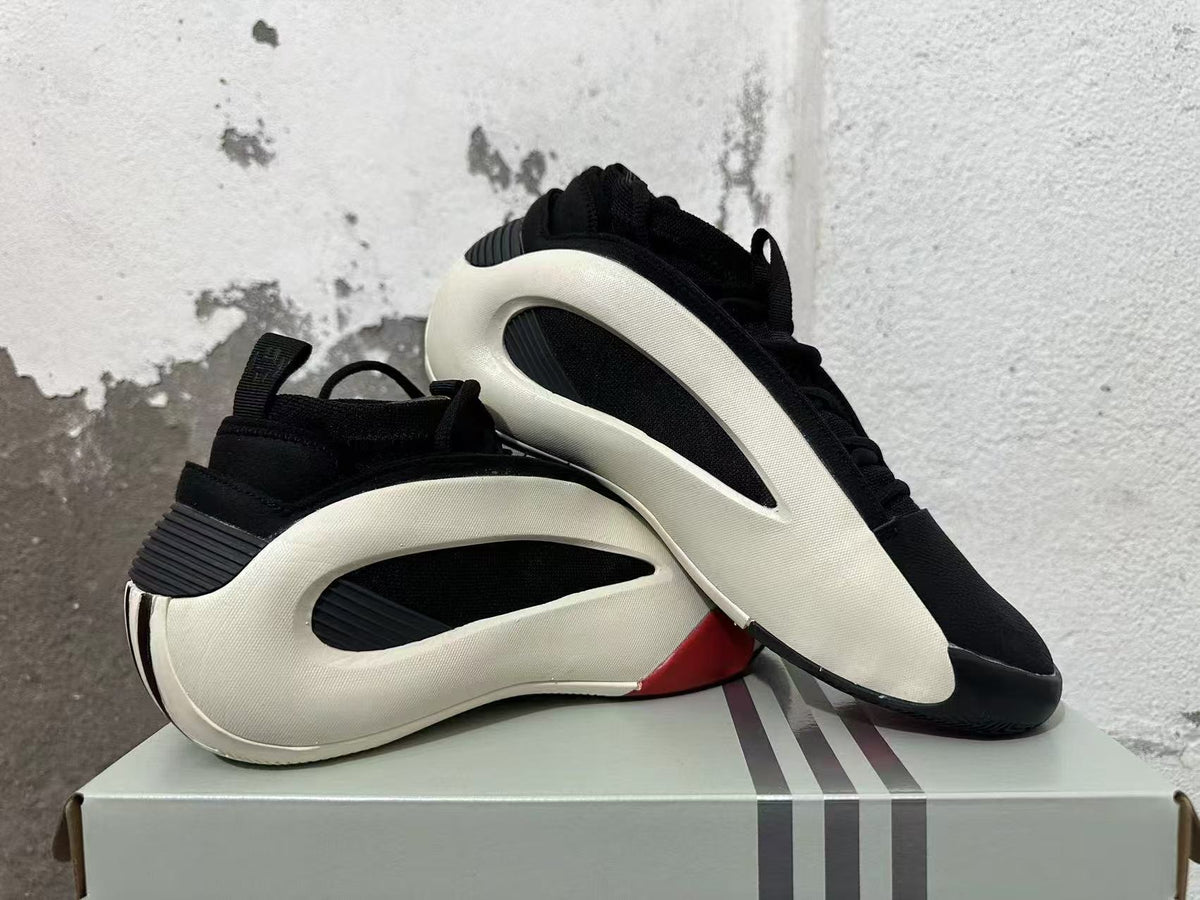 Pair of black sneakers with white sculpted side frames and red accents