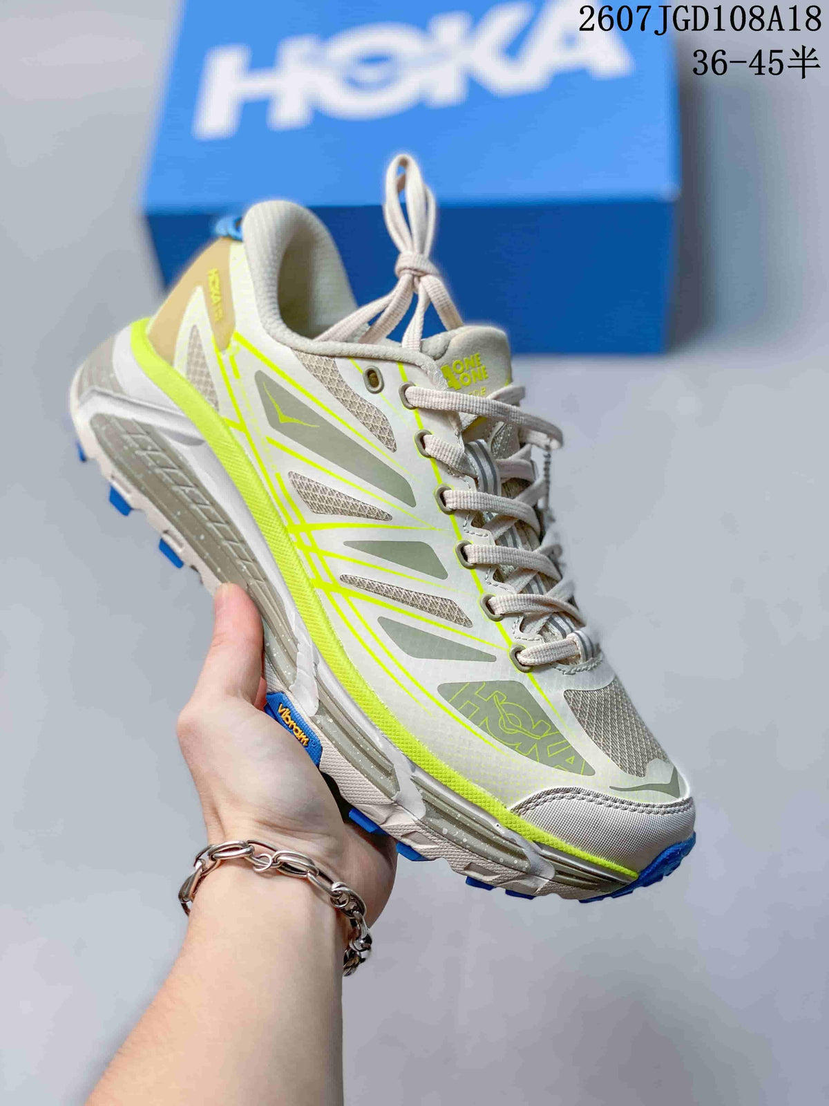 Light gray and white HOKA Mafate Speed 2 sneaker with neon yellow-green trim and blue outsole accents.