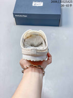 Rear view of the cream slip-on sneaker showing the padded heel collar and outsole edge.