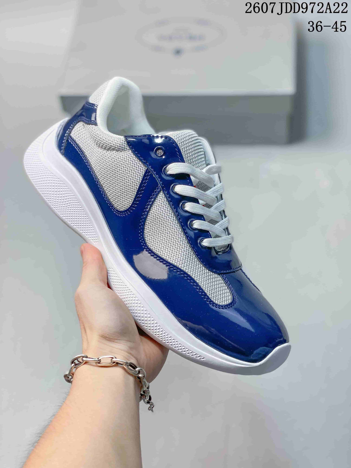 Navy and white Prada America's Cup low-top sneaker shown from a side angle.