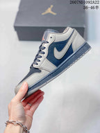 Side profile of a gray and navy low-top sneaker showing the contrasting Swoosh, layered panels, laces, and textured outsole.