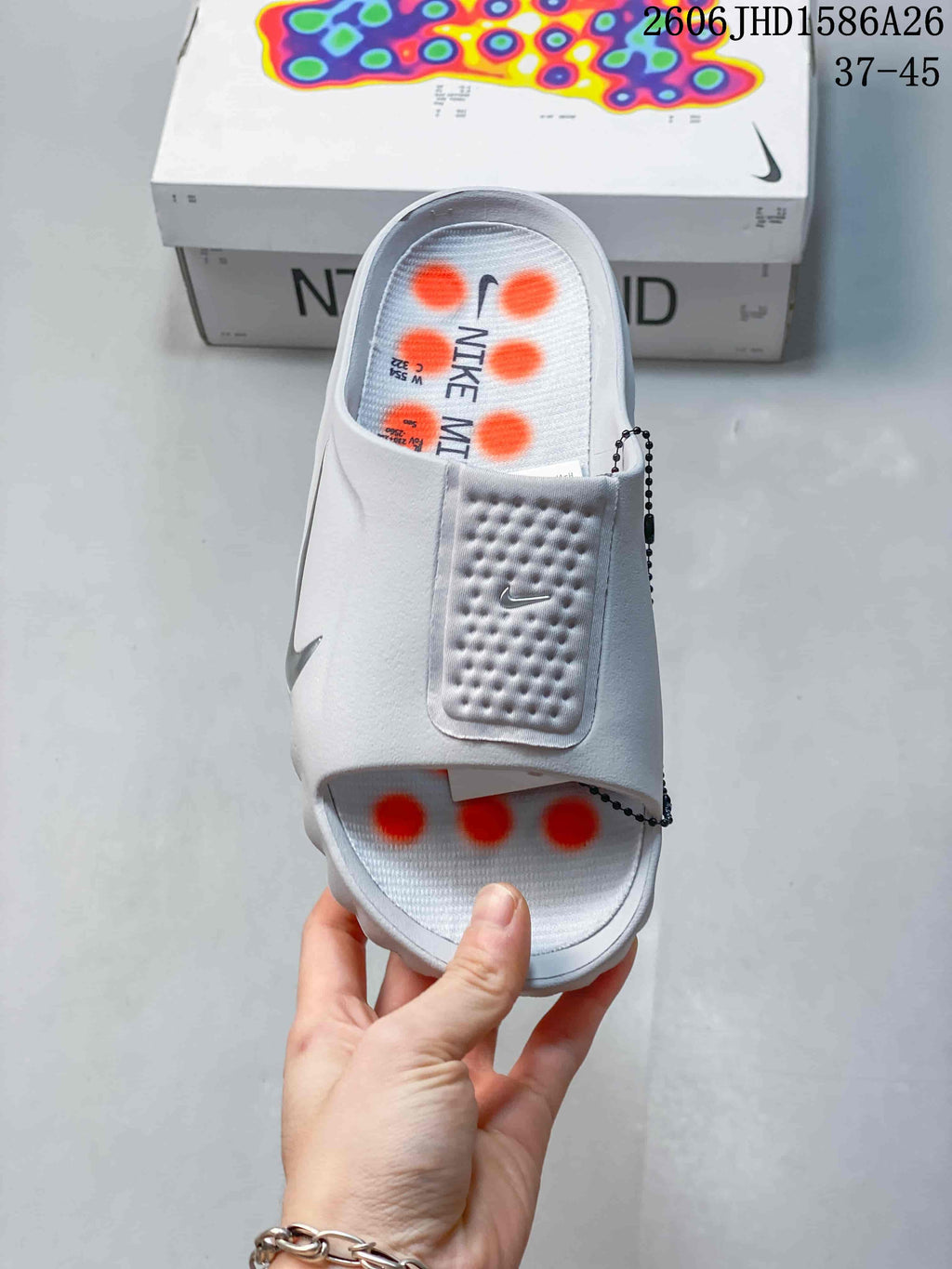 Top view of the white slide sandal with textured strap and orange footbed details