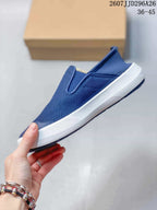 Side view of the navy slip-on shoe showing its textured upper, elastic opening, and white midsole.