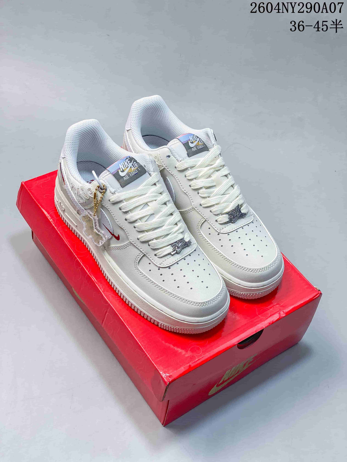 White low-top sneakers with decorative lace charms on a red box