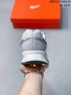 Rear view showing the padded gray heel collar, white heel structure and navy outsole detail.
