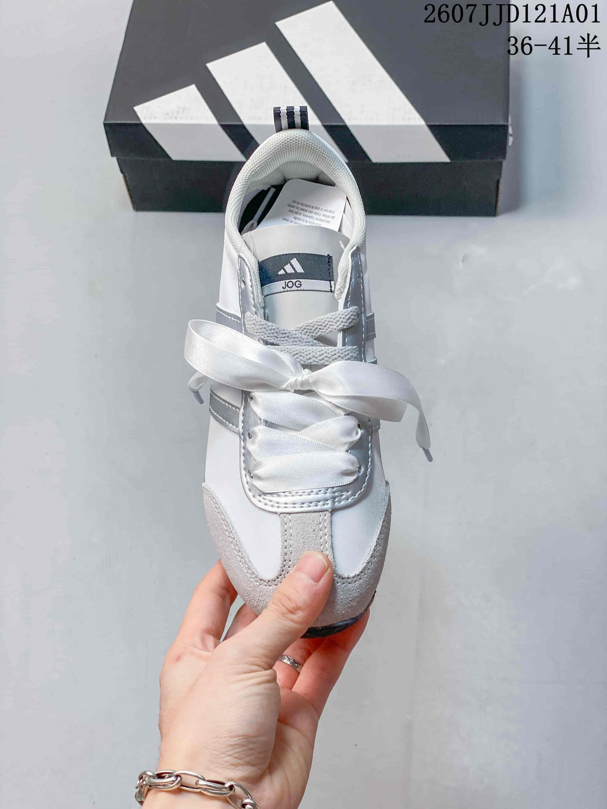 Top view of a white and gray sneaker with wide ribbon laces
