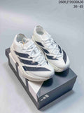 Pair of white adidas Adizero Prime X3 running shoes with dark stripes, shown from above on a box.