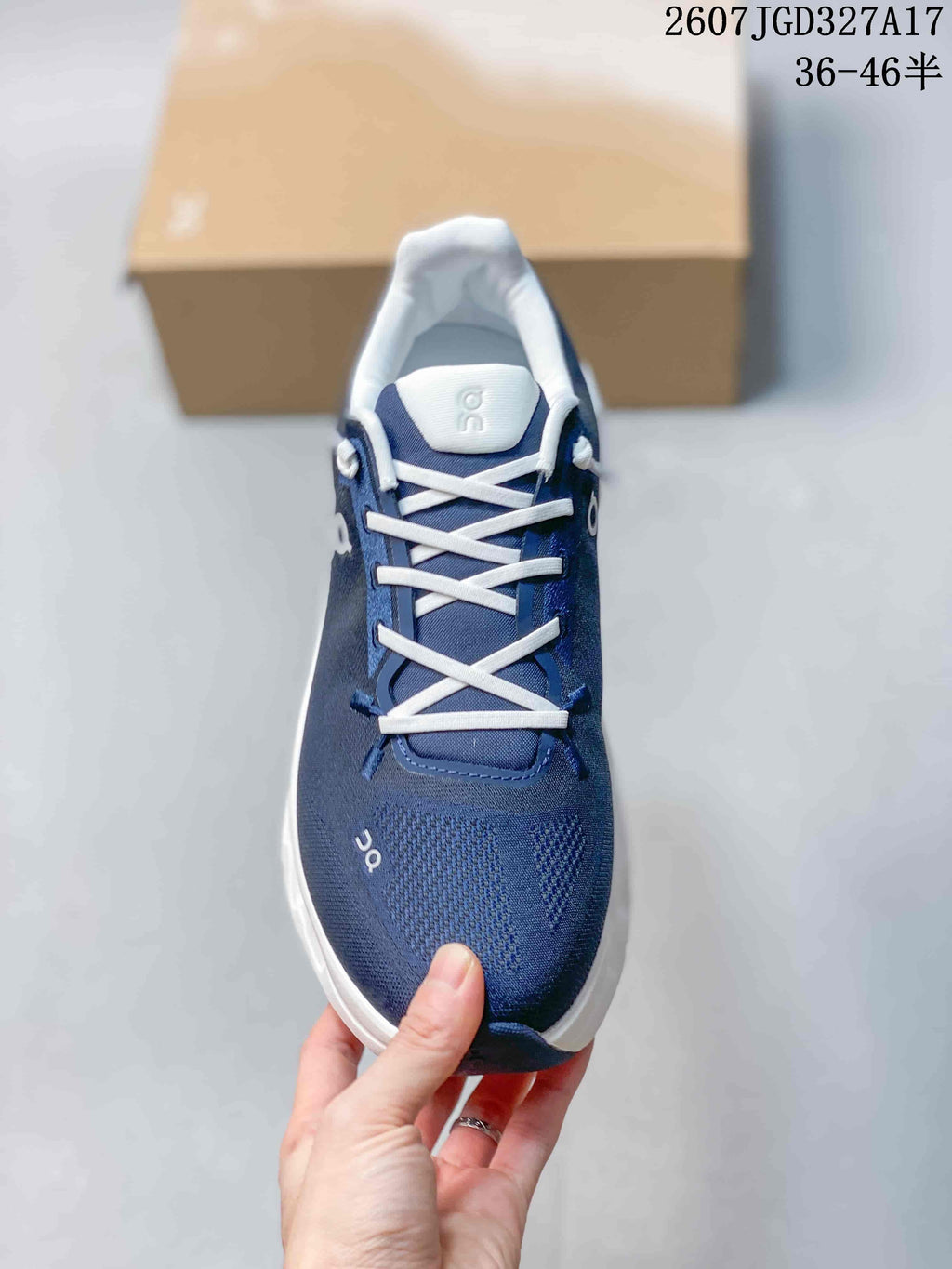 Top view of a navy sneaker showing the white laces, padded tongue, and textured toe area.