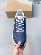 Top view of a navy sneaker showing the white laces, padded tongue, and textured toe area.