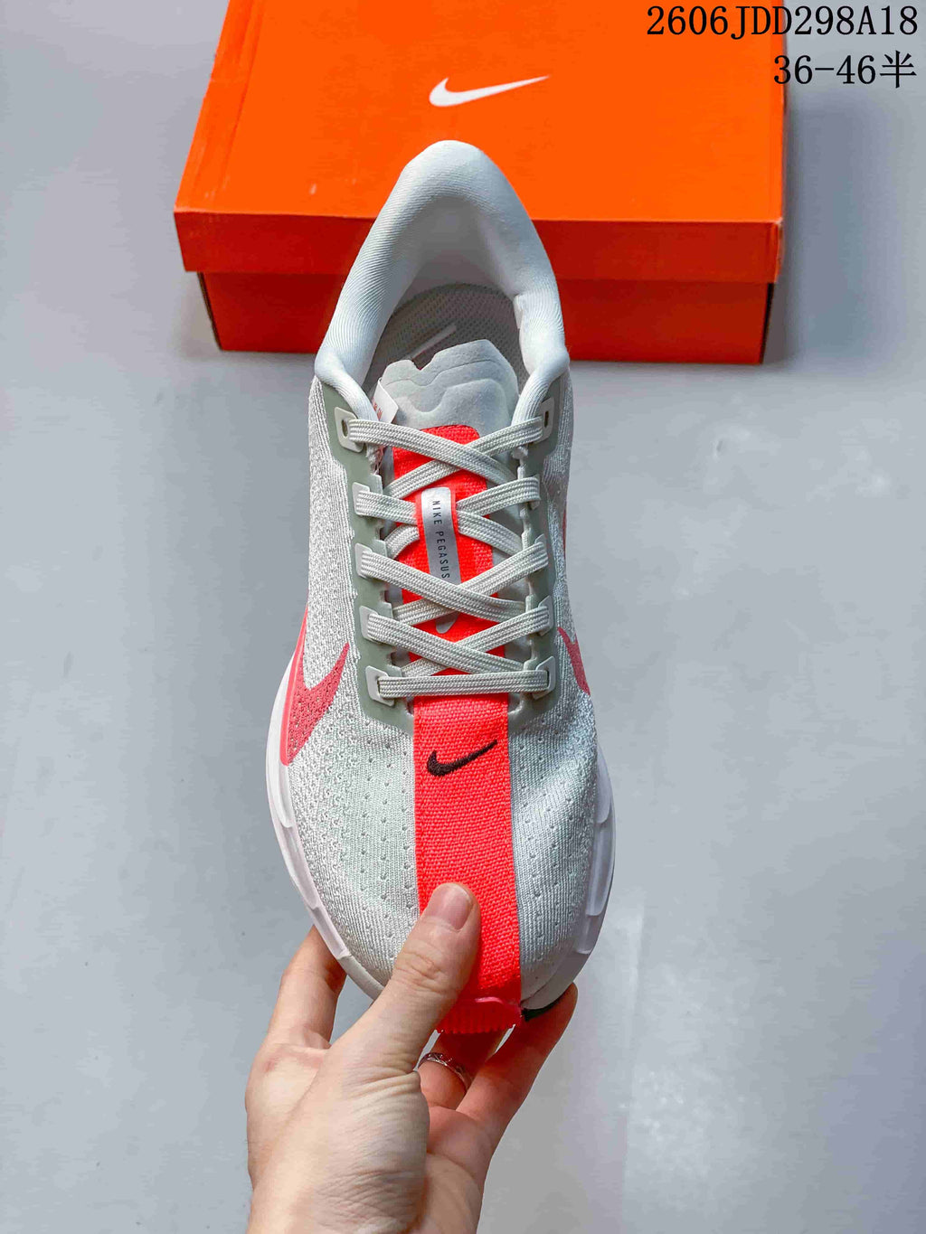 Top view of the sneaker showing grey laces, a red center tongue panel, and contrasting grey and red upper details.