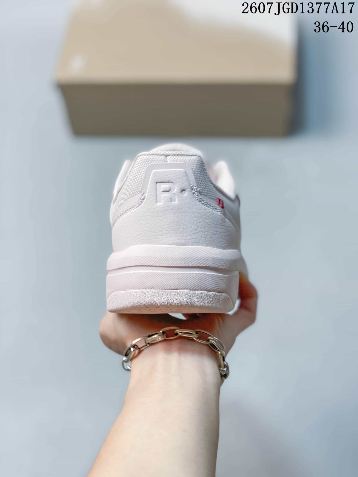 Rear view of the white and pale pink sneaker showing the padded heel, layered sole, and heel branding detail.