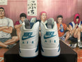 Rear view of white and blue high-top sneakers showing heel logos and contrasting accents