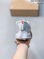 Rear view of the light gray sneaker showing the padded heel collar, On branding, and heel pull detail.