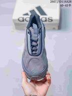 Top view of the gray sneaker showing the rounded toe, padded tongue, lace area, and contrast trim.