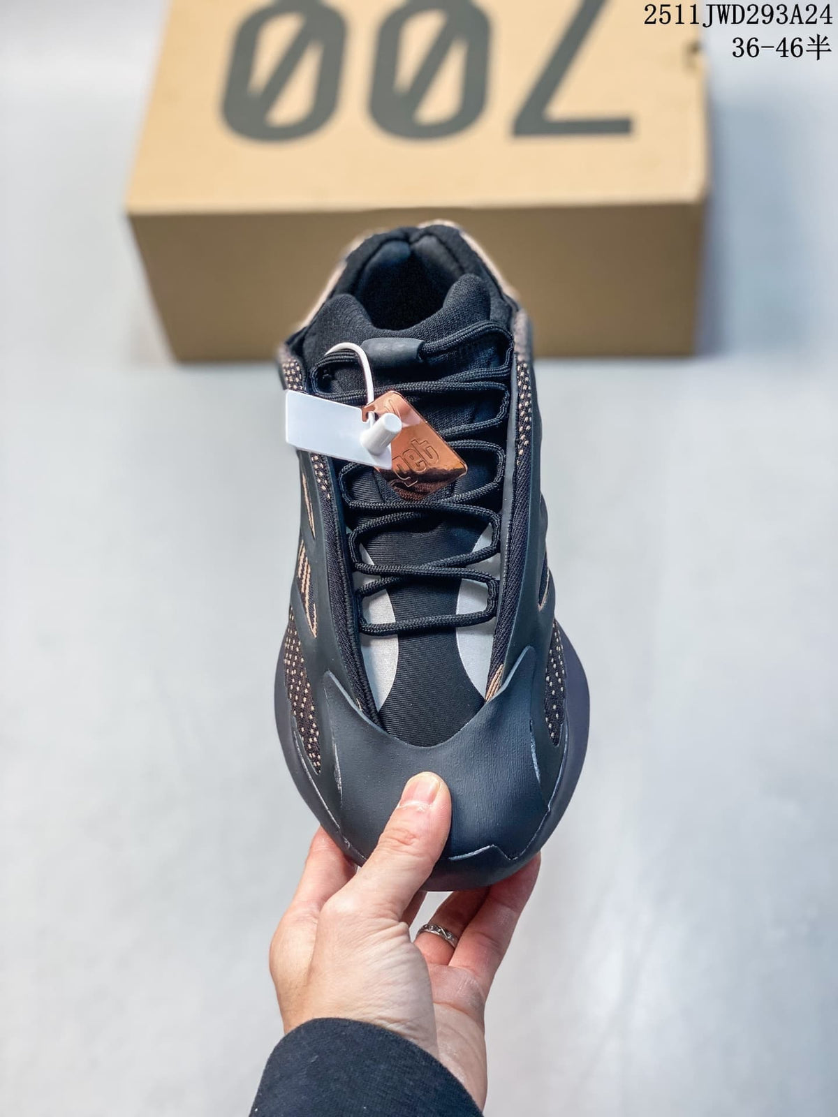 Top view of a black lace-up sneaker with tan accents, padded collar, and sculpted forefoot overlays.