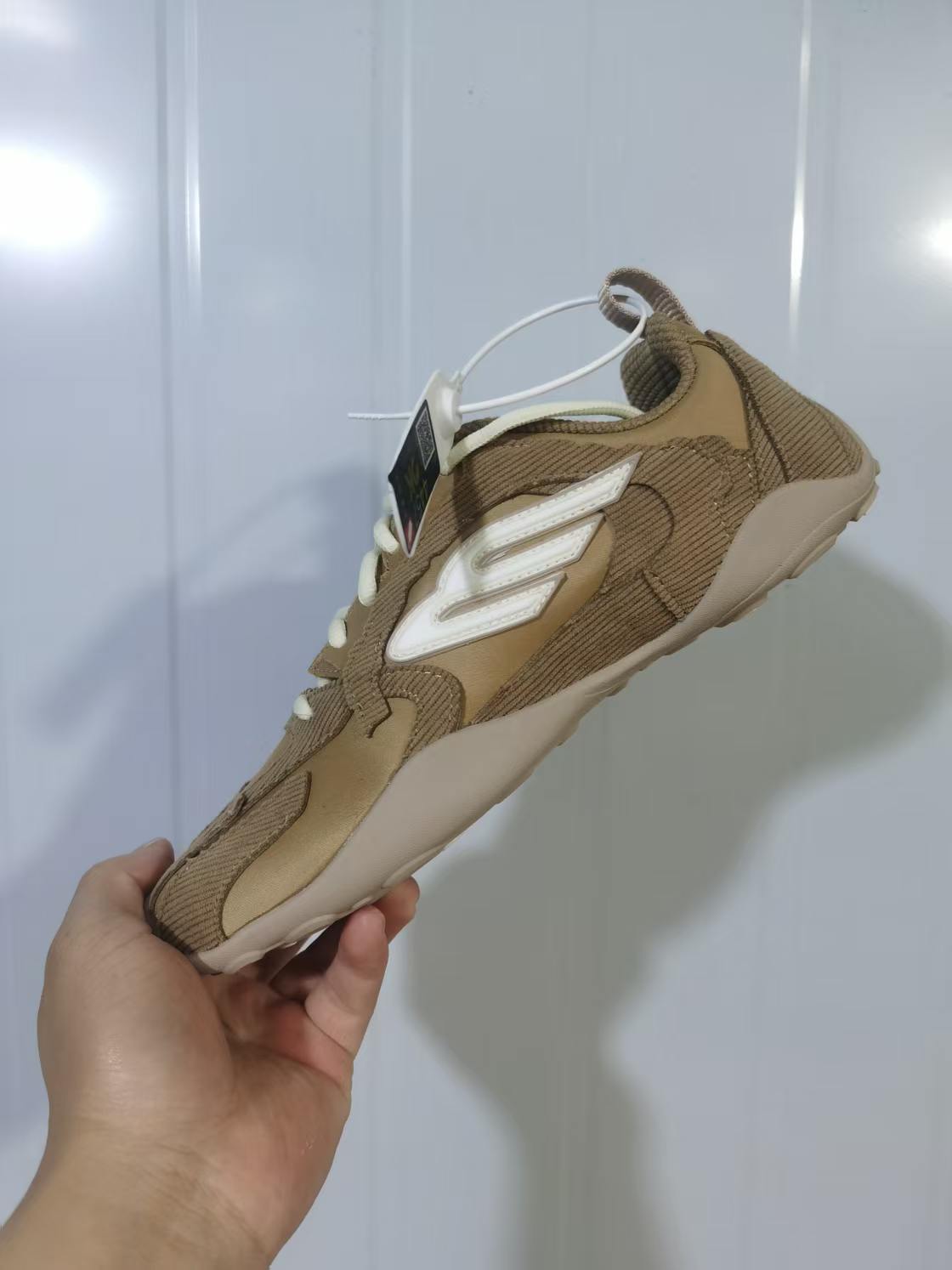 Angled rear-side view showing the layered upper, sculpted sole, and pull tab.