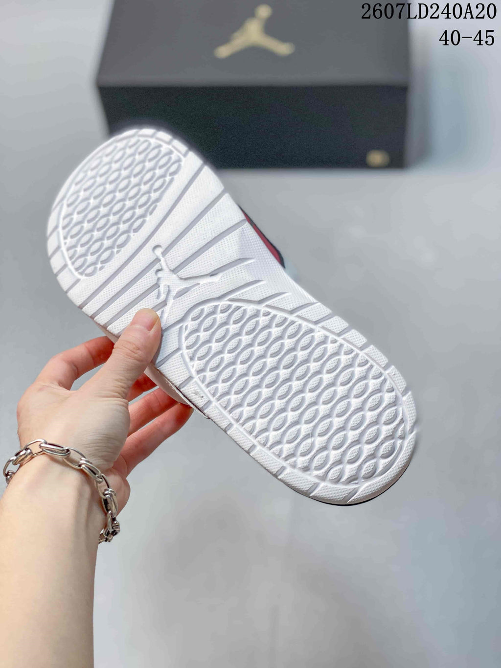 Close view of the white patterned outsole with textured traction sections; image text shows style code 2607LD240A20 and sizes 40–45.