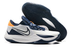 White and navy basketball shoe with orange heel accents.
