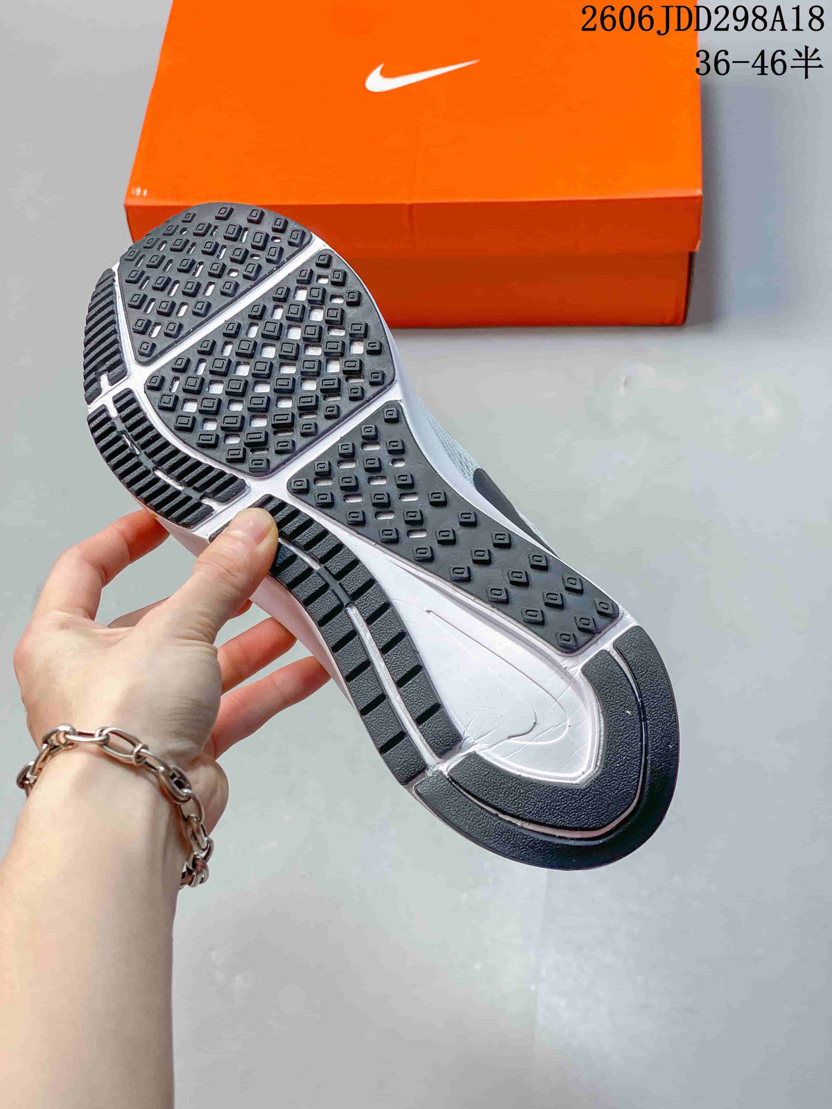 Bottom view of the sneaker showing the black-and-white rubber outsole and patterned traction pods.