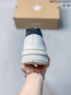 Rear view of the white sneaker showing the padded heel, layered sole, and heel branding detail.