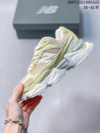 Side profile of a pale green and cream New Balance 9060R sneaker with layered panels and a sculpted outsole.