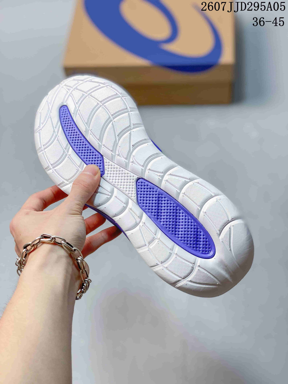 Close-up of the white and purple patterned rubber outsole showing segmented tread.