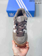 Top view of the sneaker showing the padded tongue, dark laces, brown upper, and white side stripes.