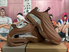 Pair of brown sneakers showing sculpted side panels and metallic silver accents