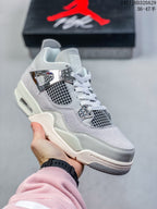 Close-up of a light grey and white high-top sneaker with metallic-look eyelets, side mesh panels, and a pale outsole.