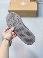 Close view of the sneaker outsole showing a geometric textured tread and Descente branding.