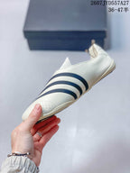 Side profile of the off-white sneaker showing the navy stripe pattern and perforated toe area.