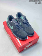 Pair of black and green Nike low-top sneakers displayed on a red Nike shoe box.