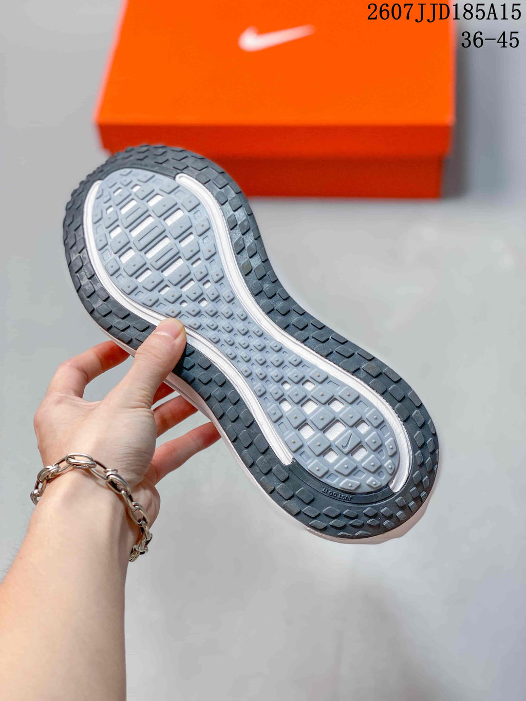 Close-up of the patterned outsole and segmented tread on a Nike Vomero Plus Run sneaker.