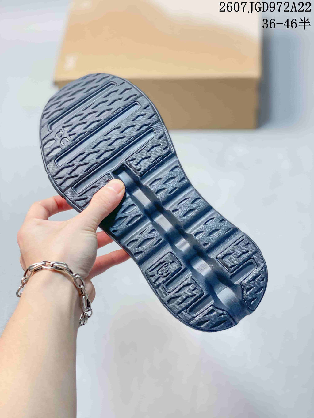 Close view of the dark textured outsole with segmented open cushioning details.