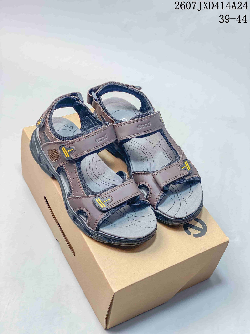 Pair of brown ECCO open-toe sandals displayed on a box, with the style code and EU size range visible above.