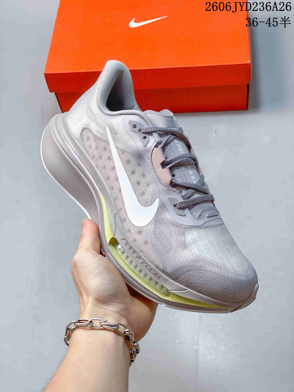 Angled side view of the silver-gray and white Nike Pegasus Plus shoe.