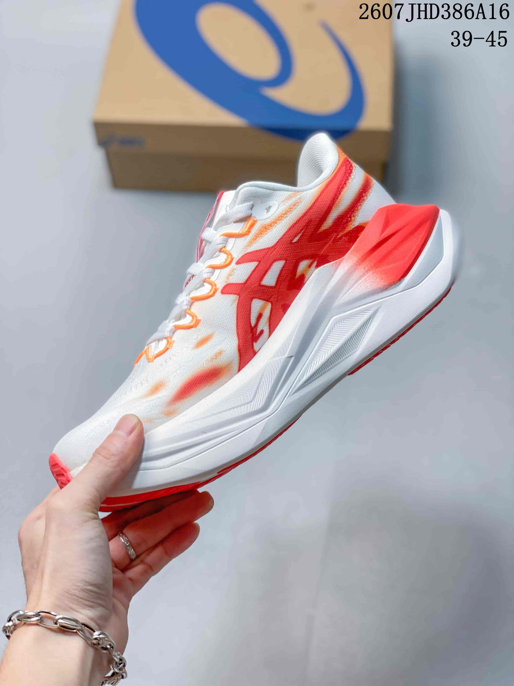 Side view showing the white upper, red ASICS branding, yellow midsole accent and layered white sole.