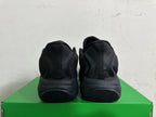 Rear view of the all-black sneakers showing the heel panels and tread.