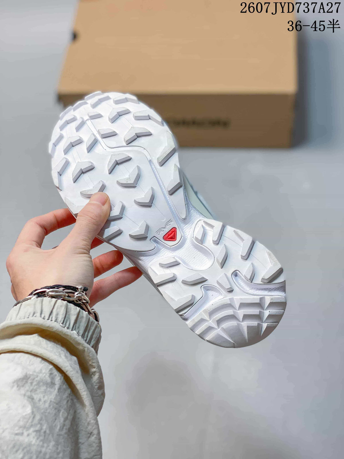 Close view of the white outsole with a prominent lugged tread pattern and Salomon outsole branding.