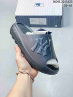 Close view of a dark navy ribbed slide sandal with raised NY lettering.