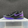 Side view of black Nike sneakers with a purple Swoosh and purple outsole.