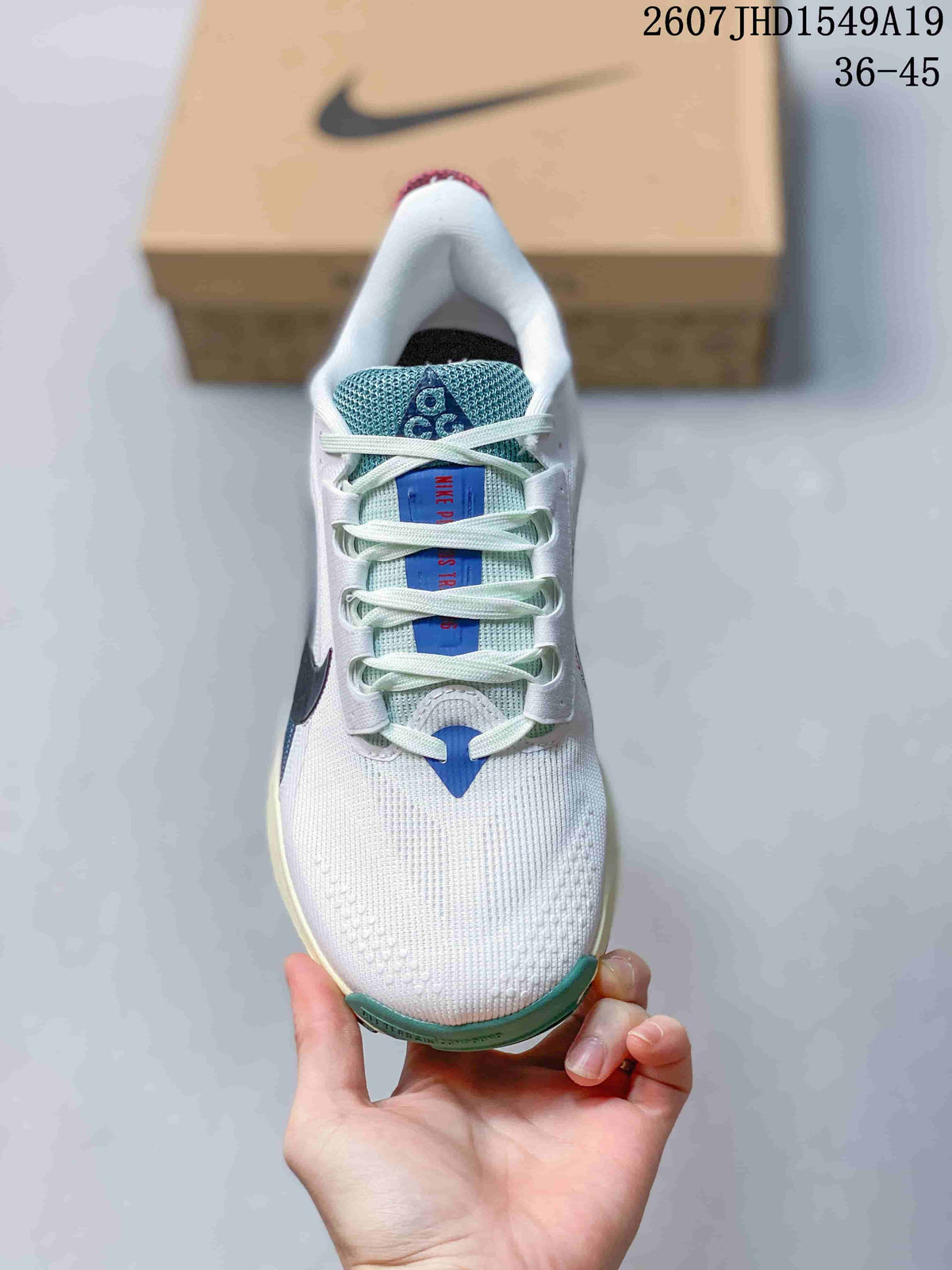 Top view showing the white toe box, teal tongue, blue tongue label, and white laces.