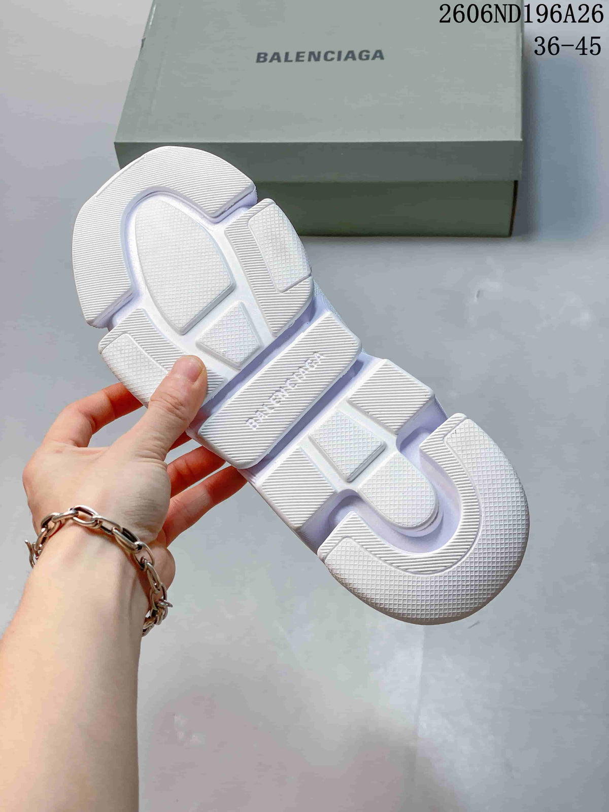 Underside view of a white sneaker showing the segmented textured outsole and branded shoe box.