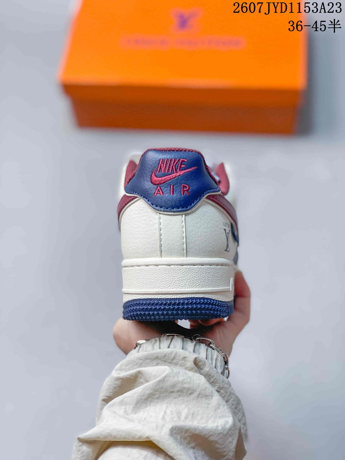Rear view showing the white heel panel, blue and burgundy accents, and Nike Air tongue branding.